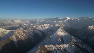 Karla kaplı dağ silsilesi nefes kesici bir manzarayla gözler önüne seriliyor, engebeli tepeler ve vadiler seriliyor, kamera giderek yaklaşarak karmaşık dokuları ve manzaranın çarpıcı detaylarını gözler önüne seriyor.