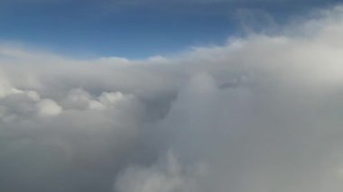 Bulutlar arası geçiş kabarık bulutlar ve mavi gökyüzünde dinamik bir hareket sergiliyor, dingin atmosferi ve bulutların yumuşak dokularını yakalıyor, sakin bir görsel deneyim yaratıyor.