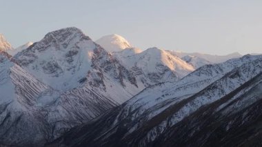 Karla kaplı dağlar ışığın alacakaranlıktan şafağa kaymasıyla görkemli zirvelerini gözler önüne seriyor, engebeli arazi ve dokuları gözler önüne seriyor, kademeli kamera zoom ile sahneleri güzelleştiriyor.