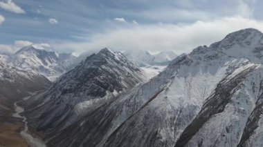 Karla kaplı tepeleri ve engebeli araziyi gözler önüne seren heybetli dağ sıraları. Kamera nefes kesen manzarada pürüzsüz bir şekilde hareket ederken doğanın güzelliğini ve manzaranın enginliğini gözler önüne seriyor.