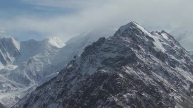 Karla kaplı görkemli dağlar geniş panoramik bir manzarayla sergileniyor. Karmaşık dokular ve dramatik tepeler gözler önüne seriliyor. Kamera nefes kesici manzarayı sorunsuz bir şekilde tarıyor.