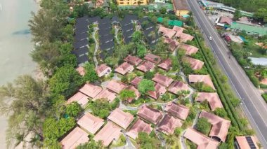 Bereketli tropikal bitki örtüsü, sayısız bungalovla geniş bir tatil köyünü çevreleyen, çatılarda yüzme havuzları ve güneş panelleri bulunan, hepsi de sakin bir sahil ve ana yol yakınlarındaki yerlerdir.