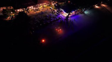 Gece vakti itfaiyeciler alevli aksesuarlar çeviriyor, büyüleyici dans hareketleri ve tropikal plaj zeminine karşı enerjik enerjisiyle otel misafirlerini eğlendiriyorlar.