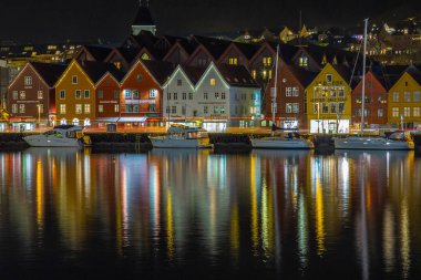 Bergen, Norveç- 12 Aralık 2015: Bryggen manzarası, geceleri Vagen limanının doğu tarafında sıralanan bir dizi Hanseatic mirası ticari binaları. Güzel aydınlatma.