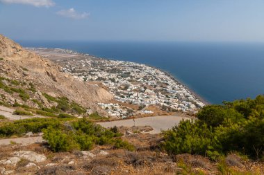 Yunanistan, Santorini Adası. Ben Vouno Dağı. Kamari tatil köyü manzarası ve siyah, volkanik plaj. Arka planda pist.