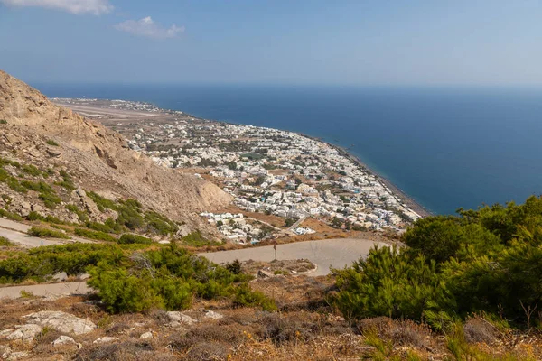 Yunanistan, Santorini Adası. Ben Vouno Dağı. Kamari tatil köyü manzarası ve siyah, volkanik plaj. Arka planda pist.