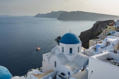Oia, Santorini Adası, Yunanistan - 18 Eylül 2020: Oia şehrindeki ünlü mavi kilise kubbeleri, beyaz mimari.
