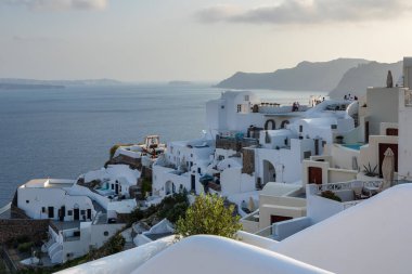 Oia, Santorini Adası, Yunanistan - 18 Eylül 2020: Köydeki ünlü, geleneksel siklodik beyaz mimarinin manzarası.