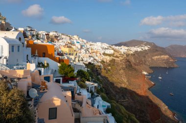 Oia, Santorini Adası, Yunanistan - 18 Eylül 2020: Köydeki ünlü, geleneksel kiklodik beyaz mimarinin manzarası. Günbatımı yaşam noktası.