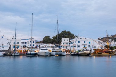 Chora, Ios Adası, Yunanistan 19 Eylül 2020 liman iskelesine demir atmış tekne ve yelkenli gemi. Akşamları limanda beyaz geleneksel binalar. Işıklandırma.