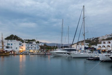 Chora, Ios Adası, Yunanistan 19 Eylül 2020 liman iskelesine demir atmış tekne ve yelkenli gemi. Akşamları limanda beyaz geleneksel binalar. Işıklandırma.