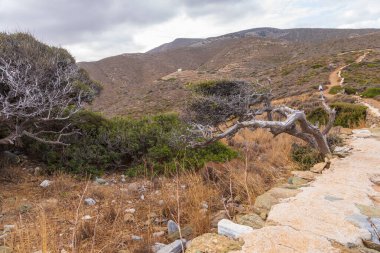 Ios Island, Greece- 20 September 2020: Tourist on the path to the prehistoric tomb of Homer. View of the mountain.