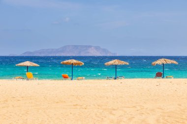 Agia Theodoti Sahili manzarası, şezlonglar ve saman şemsiyelerle, looların en sessizlerinden biri. Yunanistan.