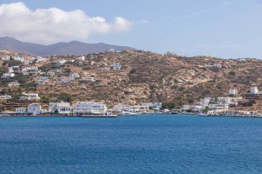 Chora, Ios Adası, Yunanistan... 20 Eylül 2020: liman iskelesine demirlemiş tekne ve yelkenli. Limanda beyaz geleneksel binalar .