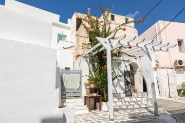 Chora, Ios Adası, Yunanistan... 20 Eylül 2020: Dükkanları ve restoranı olan eski kasabanın dar sokakları. Geleneksel, geniş mimari ve beyaz eklemli taş bir yol..