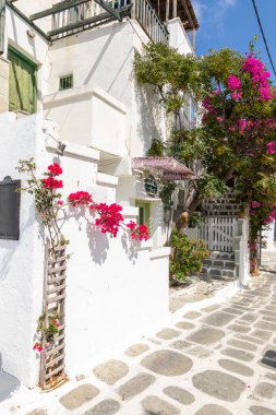 Chora, Ios Adası, Yunanistan... 20 Eylül 2020: Dükkanları ve restoranı olan eski kasabanın dar sokakları. Geleneksel, geniş mimari ve beyaz eklemli taş bir yol..