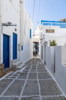 Chora, Ios Adası, Yunanistan... 20 Eylül 2020: Dükkanları ve restoranı olan eski kasabanın dar sokakları. Geleneksel, geniş mimari ve beyaz eklemli taş bir yol..