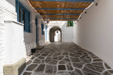 Chora, Ios Adası, Yunanistan... 20 Eylül 2020: Dükkanları ve restoranı olan eski kasabanın dar sokakları. Geleneksel, geniş mimari ve beyaz eklemli taş bir yol..