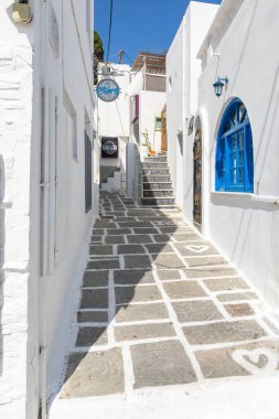 Chora, Ios Adası, Yunanistan... 20 Eylül 2020: Dükkanları ve restoranı olan eski kasabanın dar sokakları. Geleneksel, geniş mimari ve beyaz eklemli taş bir yol..