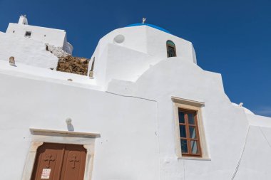 Chora, Ios Island, Greece- 20 September 2020: View of the Church of Virgin Mary of the Cliff. White building on the hill. Beautiful, sunny day.