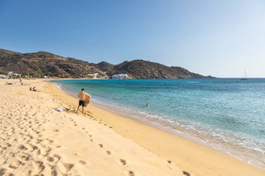 Mylopotas Sahili, Ios Adası, Yunanistan - 20 Eylül 2020: insanlar sahilde güneşleniyor ve denizde yüzüyorlar. Ios 'taki en popüler plajlardan biri..