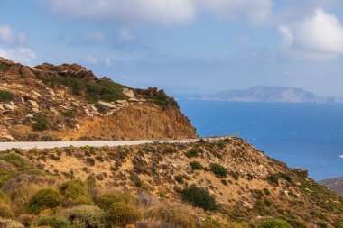 Dağ manzarası, dolambaçlı yol. Arka planda deniz. Ios Adası, Yunanistan.