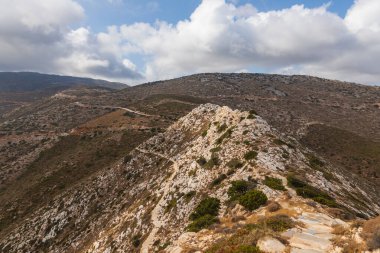 Dağ manzarası, dolambaçlı yol. Arka planda deniz. Ios Adası, Yunanistan.