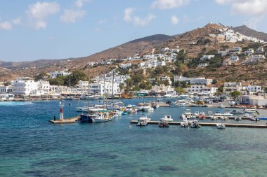 Chora, Ios Adası, Yunanistan 19 Eylül 2020 liman iskelesine demir atmış tekne ve yelkenli gemi. Tepelerdeki beyaz geleneksel binalar.