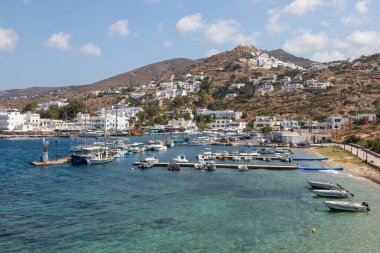 Chora, Ios Adası, Yunanistan 19 Eylül 2020 liman iskelesine demir atmış tekne ve yelkenli gemi. Tepelerdeki beyaz geleneksel binalar.