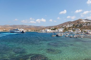 Chora, Ios Adası, Yunanistan 19 Eylül 2020 liman iskelesine demir atmış tekne ve yelkenli gemi. Tepelerdeki beyaz geleneksel binalar.