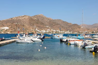 Chora, Ios Adası, Yunanistan 19 Eylül 2020 liman iskelesine demir atmış tekne ve yelkenli gemi. Tepelerdeki beyaz geleneksel binalar.