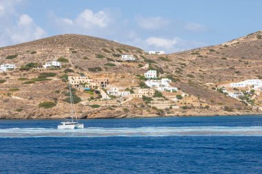 Chora, Ios Adası, Yunanistan 22 Eylül 2020, Catamaran Chora limanından ayrılıyor. Arkasında beyaz geleneksel binalar olan tepeler.