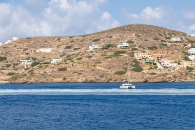 Chora, Ios Adası, Yunanistan 22 Eylül 2020, Catamaran Chora limanından ayrılıyor. Arkasında beyaz geleneksel binalar olan tepeler.