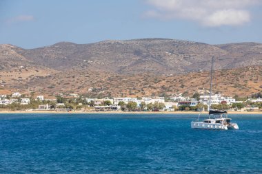 Chora, Ios Adası, Yunanistan 22 Eylül 2020, Catamaran Chora limanından ayrılıyor. Arkasında beyaz geleneksel binalar olan tepeler.