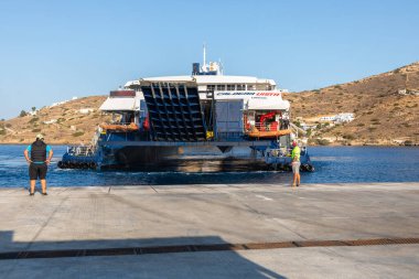 Chora, Ios Adası, Yunanistan - 23 Eylül 2020: Ios Limanı manzarası. Katamaran limana demirlemiş. Sahilde dikilen insanlar.