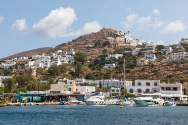Chora, Ios Adası, Yunanistan 22 Eylül 2020 liman iskelesine demir atmış tekne ve yelkenli gemi. Tepelerdeki beyaz geleneksel binalar.