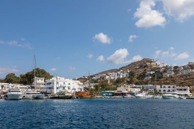 Chora, Ios Adası, Yunanistan 22 Eylül 2020 liman iskelesine demir atmış tekne ve yelkenli gemi. Tepelerdeki beyaz geleneksel binalar.
