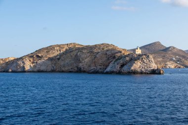 Arka plandaki kayadaki deniz feneri. Chora, Ios Adası, Yunanistan.