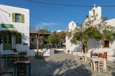 Folegandros Adası, Chora, Yunanistan - 23 Eylül 2020: Yerel restoranları olan ana meydanın manzarası. Misafirler için dışarıda masalar.