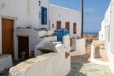 Geleneksel Yunan mimarisi Chora 'nın merkezinde. Mavi panjurlu ve kapısı olan beyaz bir bina. Folegandros Adası, Yunanistan.