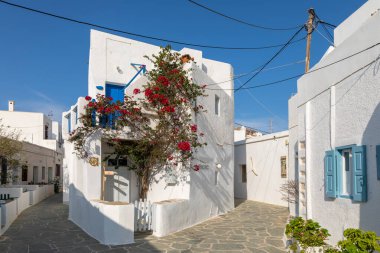 Chora, Folegandros Adası, Yunanistan - 23 Eylül 2020: Chora 'nın merkezinde geleneksel Yunan mimarisi. Mavi kepenkli ve kapısı olan beyaz bina..