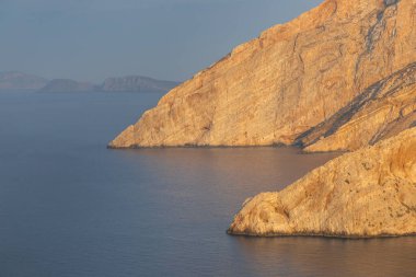 Günbatımında Folegandros adasının yüksek uçurumlarının manzarası, Kiklad Takımadaları, Yunanistan.