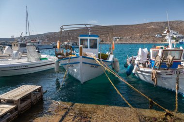 Folegandros Adası, Yunanistan - 24 Eylül 2020: Folegandros adasındaki Karavostasi marinasında demirlemiş yelkenliler ve motorlu botlar. Arka planda beyaz villalar.