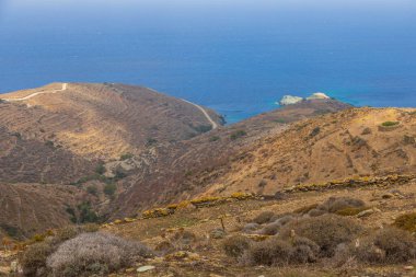 Folegandros adasının kıyı şeridi manzarası. Taş duvarlar yamaçlardan geçerek teraslar oluşturuyor. Cyclades Takımadaları, Yunanistan.
