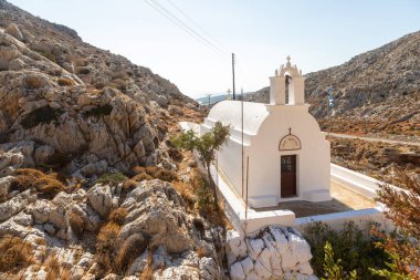 Folegandros Adası, Yunanistan - 25 Eylül 2020: Kayalar arasında geleneksel beyaz şapel Agioi Anargyroi.