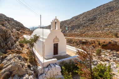 Folegandros Adası, Yunanistan - 25 Eylül 2020: Kayalar arasında geleneksel beyaz şapel Agioi Anargyroi.