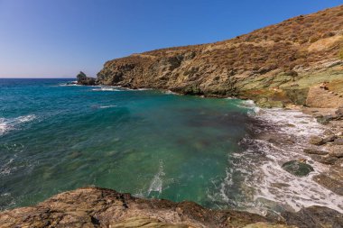 Folegandros Adası, Yunanistan - 25 Eylül 2020: Folegandros adasının kıyı manzarası ve kayalık Ampeli plajı. İnsanlar plajda güneşleniyor. Ege Denizi, Kiklad Takımadası.