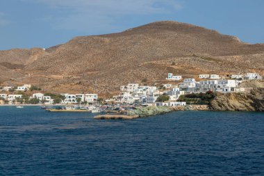 Folegandros Adası, Yunanistan - 26 Eylül 2020: Arka planda tepelerde geleneksel binalar bulunan liman manzarası.