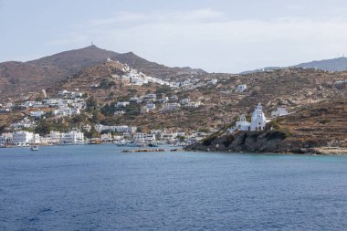 Chora, Ios Adası, Yunanistan - 26 Eylül 2020: liman manzarası ve Agia Irini, Saint Irene, Yunan Ortodoks kilisesi. Arka planda tepeler.