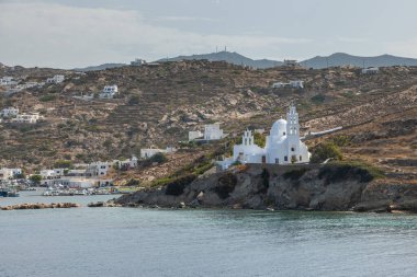 Chora, Ios Adası, Yunanistan - 26 Eylül 2020: liman manzarası ve Agia Irini, Saint Irene, Yunan Ortodoks kilisesi. Arka planda tepeler.
